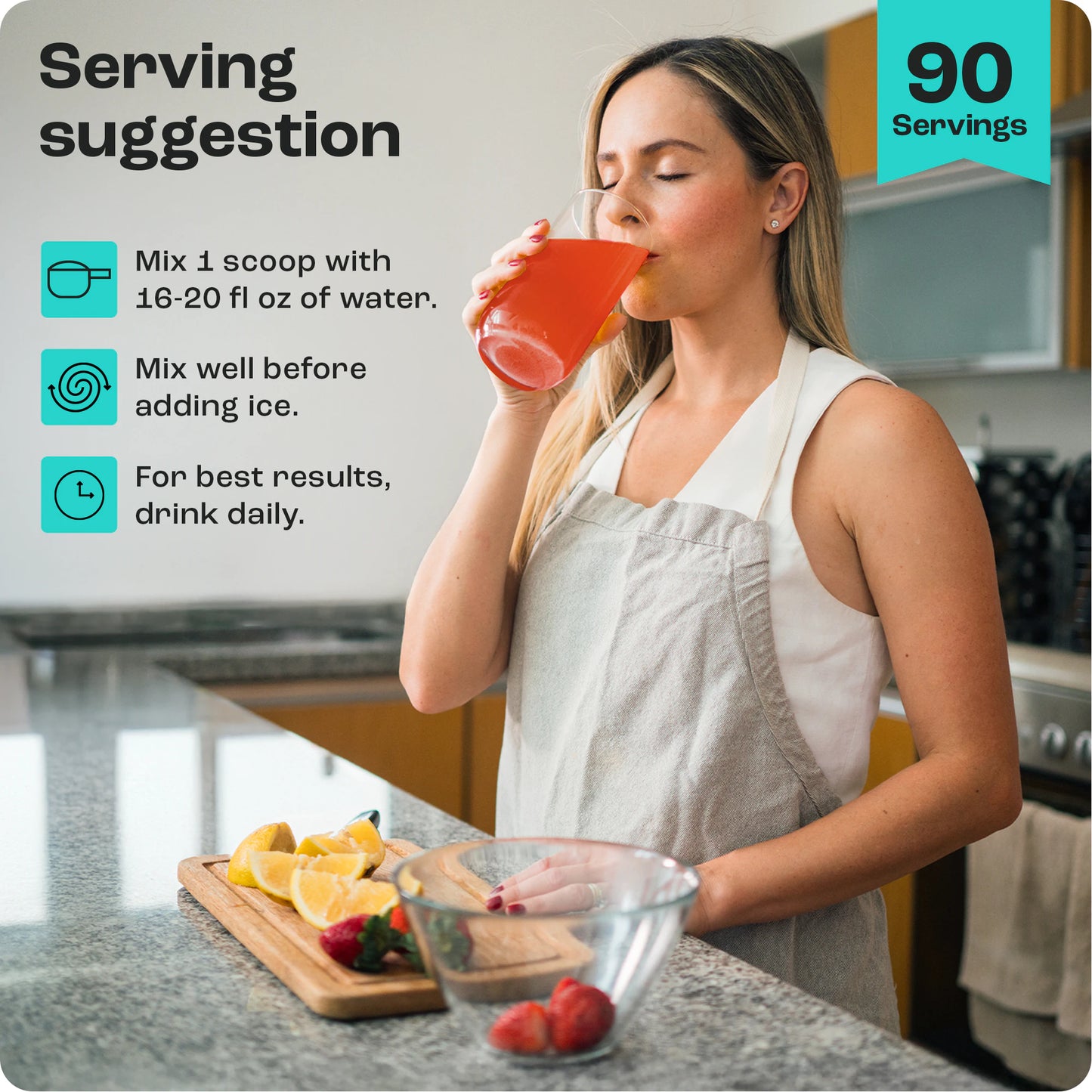 Woman enjoying Electrolyte Recovery Plus Powder, a zero-calorie orange drink, in a kitchen with fruit.