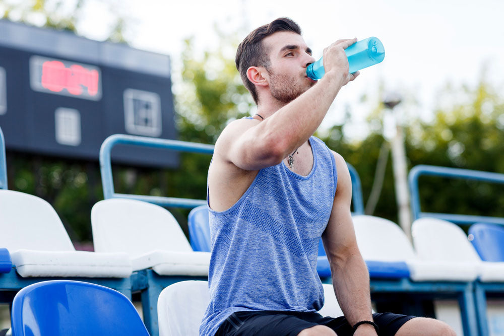 man drinking from sports bottle