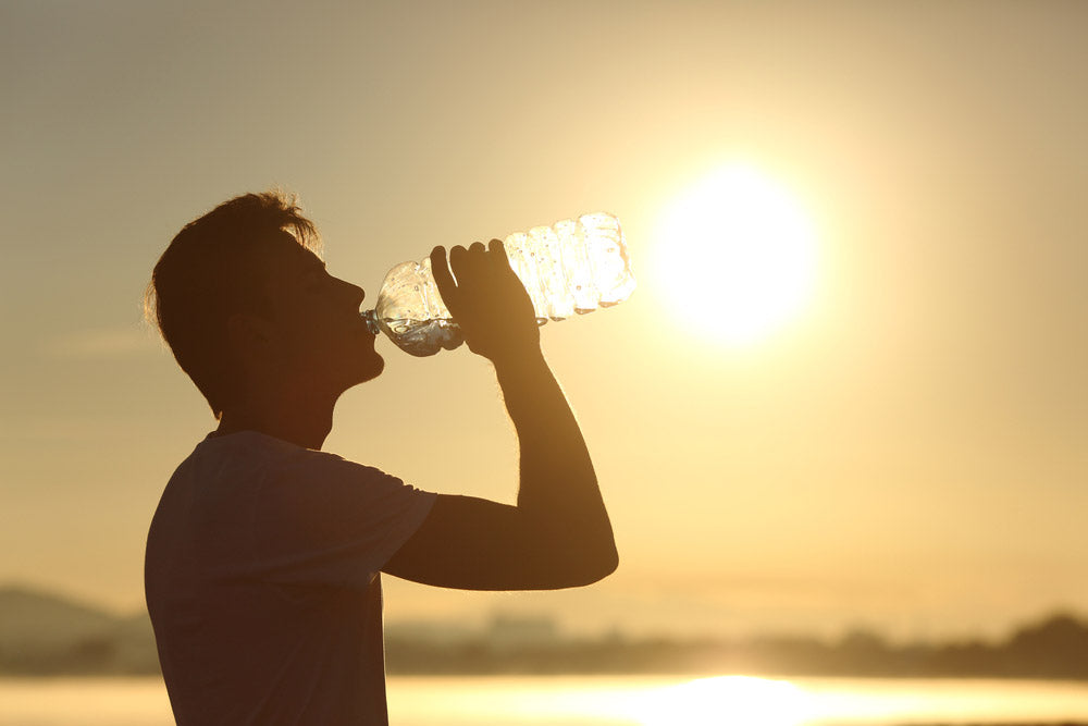 man silhouette while drinking water