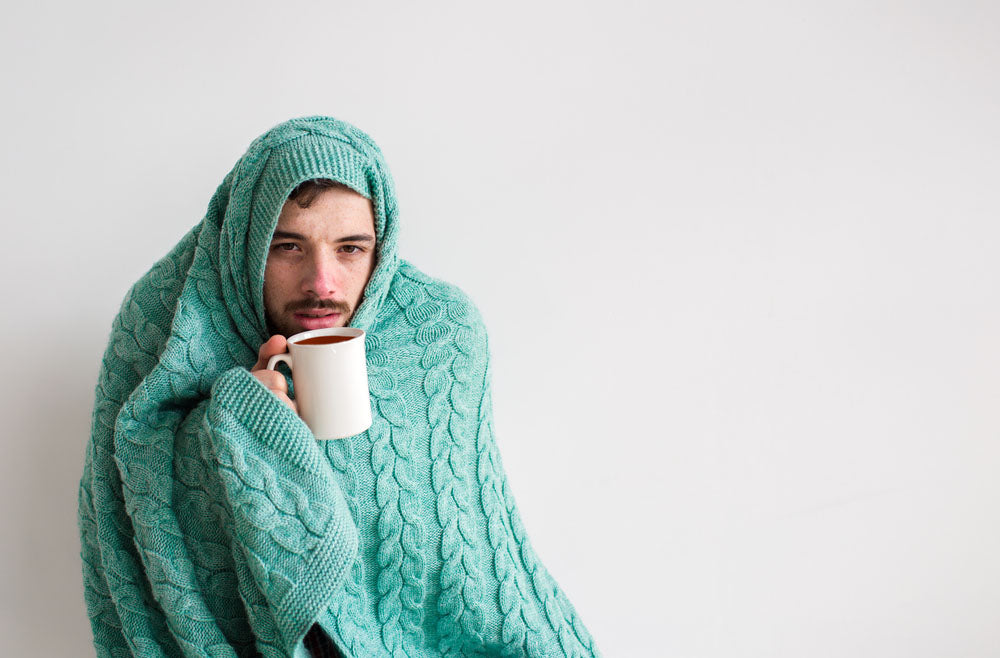 sick man wrapped in blanket