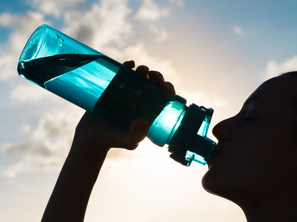 silhouette drinking from bottle