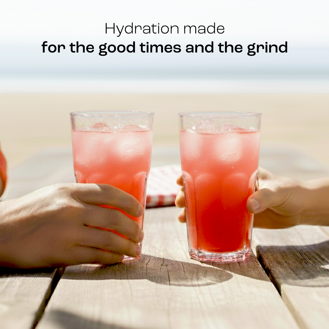 Two hands hold glasses with red liquid, enjoying Electrolyte Recovery Plus Powder (Sugar-Free).