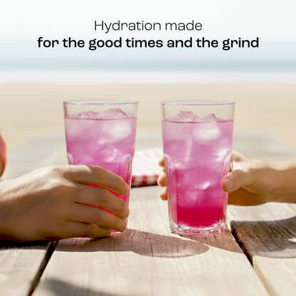 Two hands holding Electrolyte Recovery Plus Powder (Sugar-Free) drinks by the beach with hydration text above.