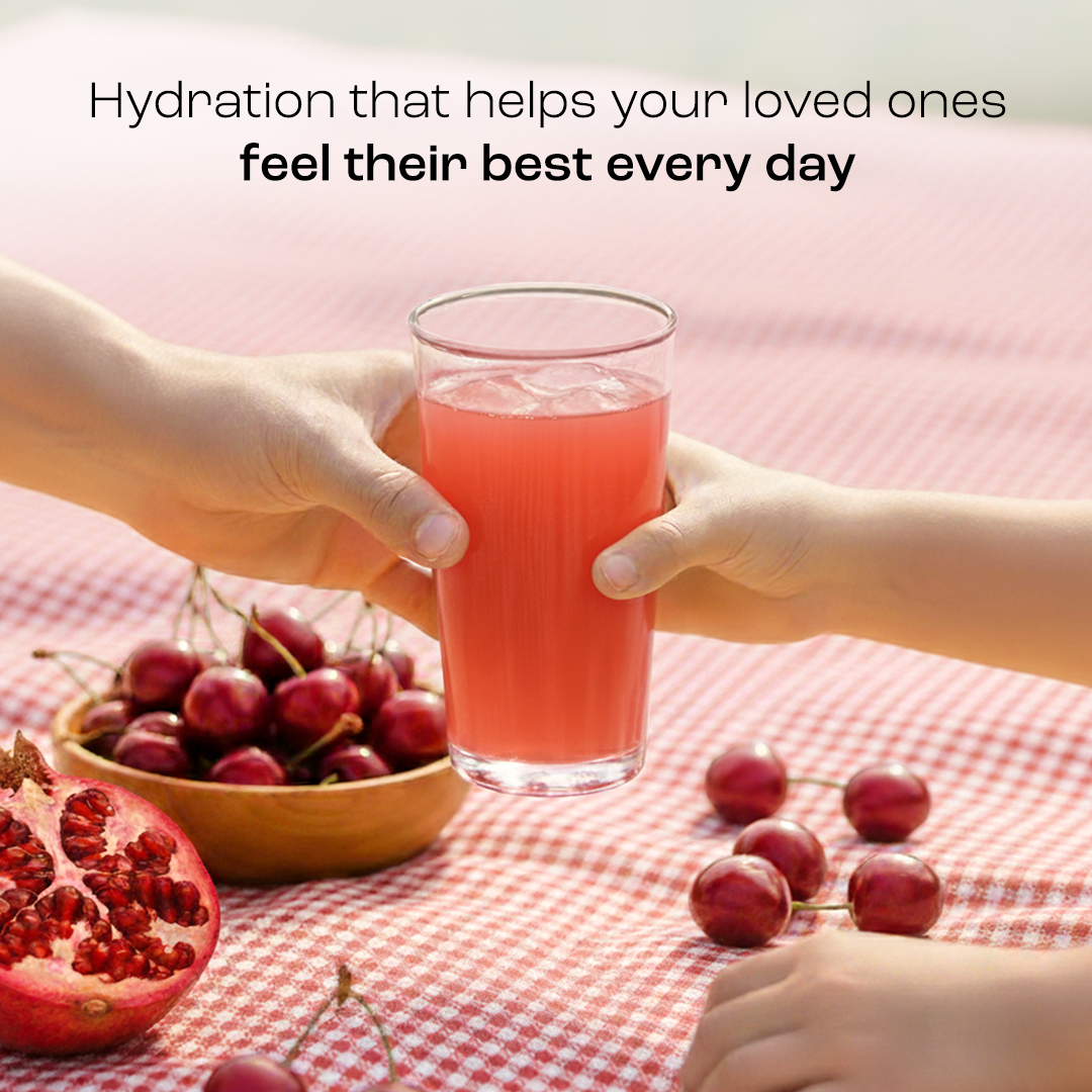 Adult and child hands hold a glass of Electrolyte Recovery Plus Powder (Sugar-Free) over a picnic table.