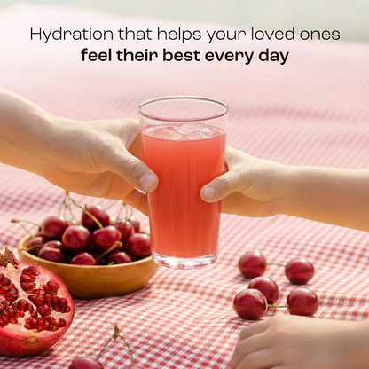 Adult and child hands hold a glass of Electrolyte Recovery Plus Powder (Sugar-Free) over a picnic table.
