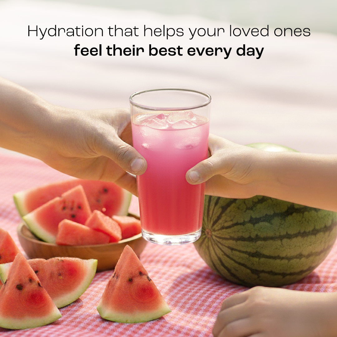 Two hands holding a glass of Electrolyte Recovery Plus Powder (Sugar-Free) with watermelon slices nearby.
