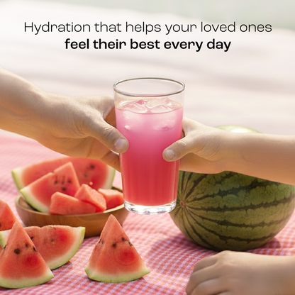 Two hands holding a glass of Electrolyte Recovery Plus Powder (Sugar-Free) with watermelon slices nearby.
