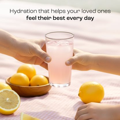 Adult and child’s hands holding a glass of Electrolyte Recovery Plus Powder (Sugar-Free) over picnic blanket.