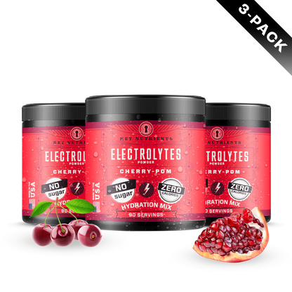 Three tubs of Electrolyte Recovery Plus Powder in red packaging, ideal for a hydration drink with cherries and pomegranates displayed in front. Suitable for a Keto diet.