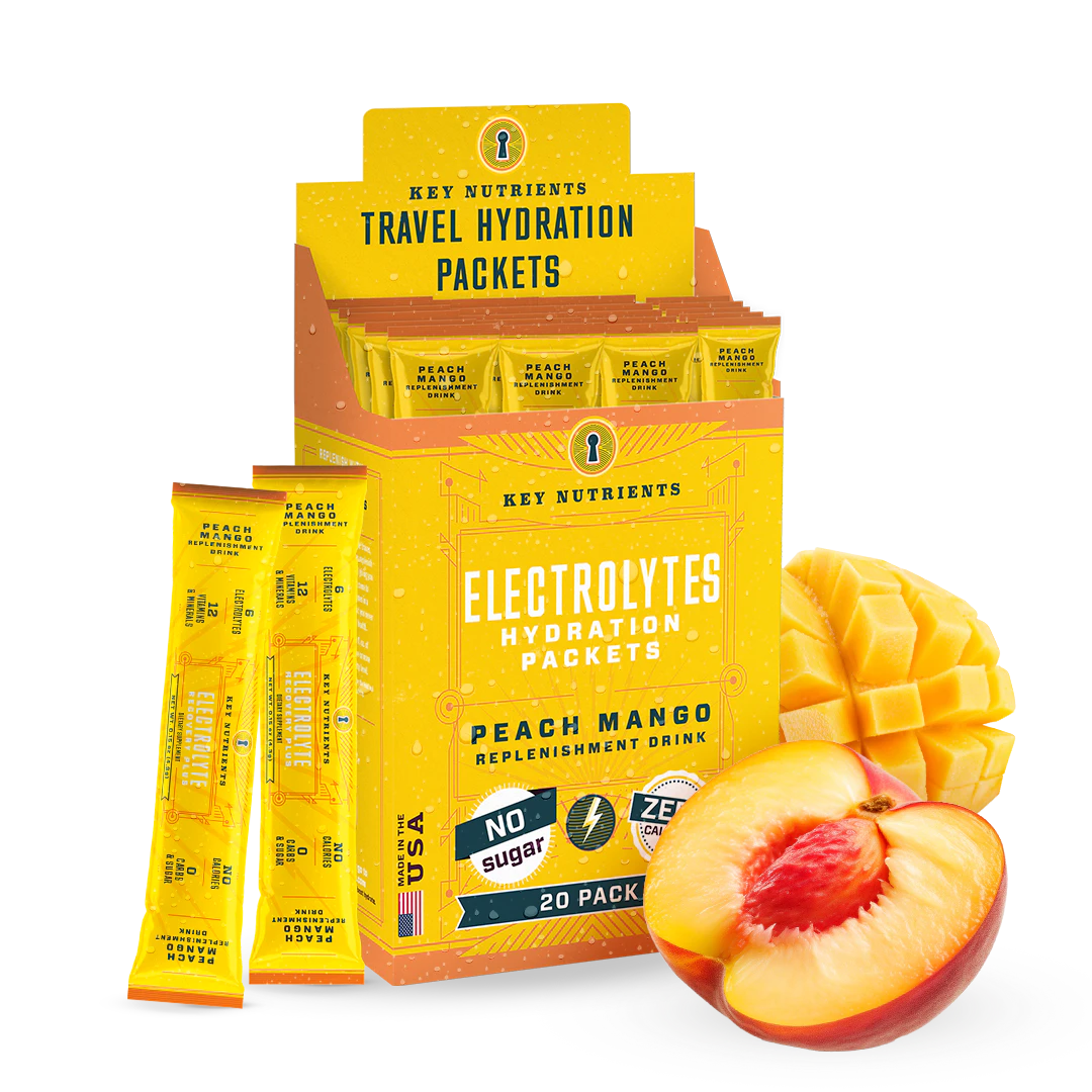 Box of Electrolyte Recovery Plus Powder (Sugar-Free) packets with sliced mango and peach in front, ideal for a Keto Diet Friendly hydration drink.