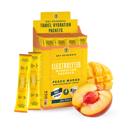 Box of Electrolyte Recovery Plus Powder (Sugar-Free) packets with sliced mango and peach in front, ideal for a Keto Diet Friendly hydration drink.