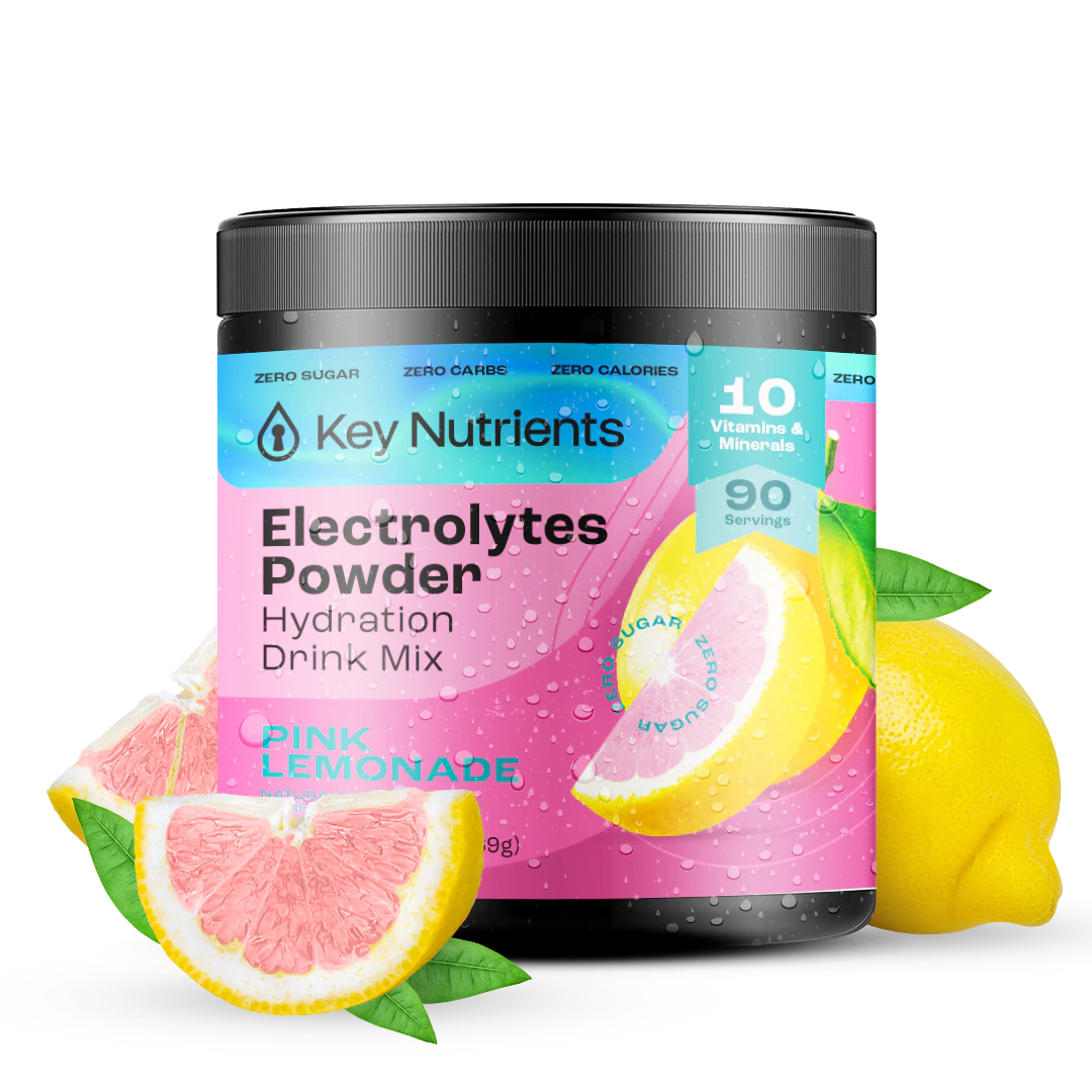 A jar of Electrolyte Recovery Plus Powder (Sugar-Free) sits enticingly beside pink lemonade and lemon slices, offering a refreshing hydration drink.