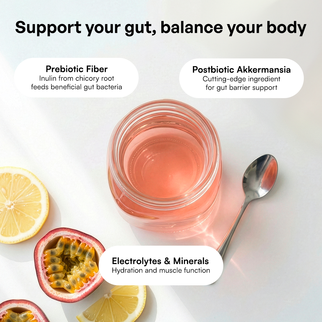 A jar of Gut Health pink drink with a spoon, lemon, passion fruit, and gut health benefit labels.