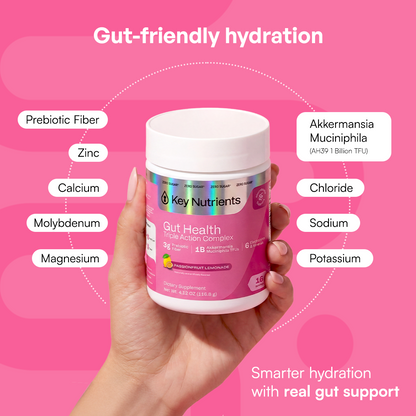 A hand holds a Gut Health jar on a pink background to promote digestive health.